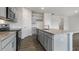 Spacious kitchen featuring gray cabinets, granite counters, a center island, and stainless steel appliances at 152 Global Ave, Fuquay Varina, NC 27526
