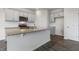Modern kitchen with gray cabinets, granite countertops, stainless steel appliances, and a center island at 152 Global Ave, Fuquay Varina, NC 27526