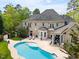 Aerial view of the home's exterior, highlighting the pool area and the surrounding landscape and brick exterior at 16106 Morehead, Chapel Hill, NC 27517