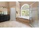 The bathroom boasts a soaking tub with an arched window and separate walk-in shower at 16106 Morehead, Chapel Hill, NC 27517