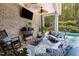 Covered patio seating area with comfortable sofas, ceiling fans, and a television for outdoor entertaining at 16106 Morehead, Chapel Hill, NC 27517