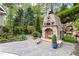 A charming stone outdoor fireplace with decorative accents and surrounding landscaping, creating a cozy ambiance at 16106 Morehead, Chapel Hill, NC 27517