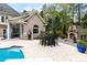 View of outdoor dining and kitchen area featuring a brick grill, dining table, and manicured garden at 16106 Morehead, Chapel Hill, NC 27517