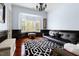 Cozy sitting room featuring a black leather couch, a bay window, and hardwood floors at 16106 Morehead, Chapel Hill, NC 27517