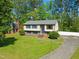 Two-story home with a manicured lawn and a long driveway leading to a detached garage at 1624 Cone Ave, Apex, NC 27502