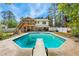 Backyard view of a swimming pool and diving board; two-story home with screened-in porch and fenced backyard at 1624 Cone Ave, Apex, NC 27502