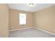 This bedroom features neutral carpeting and a window providing natural light at 2 White Spruce Ct, Durham, NC 27703