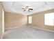 Spacious bedroom featuring a tray ceiling with fan and neutral carpeting at 2 White Spruce Ct, Durham, NC 27703