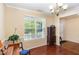 Bright dining room with hardwood floors, a chandelier, and a large window at 2 White Spruce Ct, Durham, NC 27703