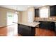 Modern kitchen with dark cabinets, granite countertops, and a center island at 2 White Spruce Ct, Durham, NC 27703