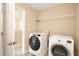 Functional laundry room with modern washer and dryer units, and storage shelving at 2 White Spruce Ct, Durham, NC 27703