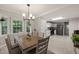 Dining room with view into kitchen, a modern chandelier and view to back yard at 2004 Valley Ridge Ct, Raleigh, NC 27603