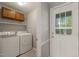 Functional laundry room with washer, dryer, cabinet, and convenient access to the exterior at 2004 Valley Ridge Ct, Raleigh, NC 27603