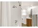 Bathroom featuring a shower with rain shower head, wood vanity, and a window at 2014 Walnut St, Durham, NC 27705