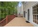 View of tan stained wood deck with access to home, surrounded by trees at 207 Ashley Brook Ct, Cary, NC 27513