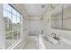 Bright bathroom featuring a vanity, toilet, shower-tub combo, and a large window at 207 Ashley Brook Ct, Cary, NC 27513