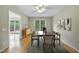 Elegant dining room with a ceiling fan, modern table, and ample natural light from the large window at 207 Ashley Brook Ct, Cary, NC 27513