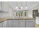 Kitchen island featuring granite countertops, a stainless steel sink, and white cabinets at 207 Ashley Brook Ct, Cary, NC 27513