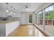 Bright kitchen nook with hardwood floors, white cabinets, granite countertops, and large windows at 207 Ashley Brook Ct, Cary, NC 27513