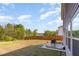Expansive backyard with a wooden fence, lush trees, and a cozy patio seating area at 217 Braeburn Dr, Graham, NC 27253