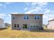A spacious backyard with a gray house, well-kept lawn and open patio area at 217 Braeburn Dr, Graham, NC 27253