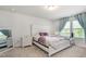 Bright bedroom with a white carved headboard, stylish side table, and coordinating curtains for a cohesive design at 217 Braeburn Dr, Graham, NC 27253