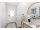 Bright entryway showcasing modern decor, a sleek console table, round mirror, and white front door at 217 Braeburn Dr, Graham, NC 27253