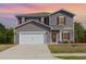 Charming two-story home with a two-car garage, gray siding and complementary dark red shutters at 217 Braeburn Dr, Graham, NC 27253