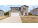Charming two-story home boasts gray siding, a white garage door, and tidy front lawn at 217 Braeburn Dr, Graham, NC 27253