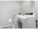 Efficient laundry room featuring modern washer and dryer units with convenient shelving for storage at 217 Braeburn Dr, Graham, NC 27253