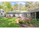 Expansive backyard featuring a well-maintained lawn, brick patio, and mature trees for a private retreat at 2225 Whitley Dr, Durham, NC 27707