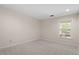 This bedroom features neutral walls and carpet, and a large window overlooking the yard at 2225 Whitley Dr, Durham, NC 27707