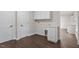 Bright laundry room features custom cabinets, wooden floors, and convenient access to other parts of the home at 2225 Whitley Dr, Durham, NC 27707