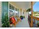 Inviting front porch with a wooden bench, decorative pillows, fern, and green shutters at 226 Marquis Dr, Cameron, NC 28326