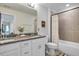 Bright bathroom with a double sink vanity featuring white cabinets, granite countertops, and a shower with neutral tile at 2283 Grants Pass Sta, Apex, NC 27502