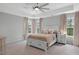 Serene bedroom with neutral tones, plush carpeting, tray ceiling, and ample natural light from multiple windows at 2283 Grants Pass Sta, Apex, NC 27502