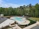 Aerial view of a community pool with lounge chairs, a playground, and lush greenery, showcasing recreational amenities at 2283 Grants Pass Sta, Apex, NC 27502