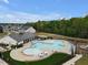 Aerial view of a community pool and clubhouse, surrounded by trees and houses, ideal for leisure and community events at 2283 Grants Pass Sta, Apex, NC 27502