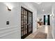Bright hallway featuring hardwood floors, decorative trim, and french doors at 2283 Grants Pass Sta, Apex, NC 27502