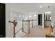 Hallway with hardwood railing and staircase leading to an upper level, showcasing natural light and a neutral color scheme at 2283 Grants Pass Sta, Apex, NC 27502