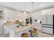 Modern kitchen boasts white cabinetry, granite countertops, stainless steel appliances, and a spacious center island with barstool seating at 2283 Grants Pass Sta, Apex, NC 27502