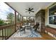 Covered back porch with ceiling fan, stone fireplace, and outdoor seating at 233 Pointe Park Cir, Holly Springs, NC 27540