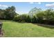 View of a well-maintained backyard, featuring lush grass, decorative plantings, and privacy fencing at 233 Pointe Park Cir, Holly Springs, NC 27540