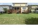 View of the home's backyard featuring lush grass, a wooden porch, and decorative plantings at 233 Pointe Park Cir, Holly Springs, NC 27540