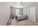 Bright bedroom featuring a ceiling fan, carpeted floor, and charming floral bedding at 233 Pointe Park Cir, Holly Springs, NC 27540