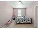 Bright bedroom featuring a ceiling fan, carpeted floor, and charming floral bedding at 233 Pointe Park Cir, Holly Springs, NC 27540