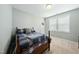 Carpeted bedroom featuring a bed, natural light, and a playful basketball hoop on the door at 233 Pointe Park Cir, Holly Springs, NC 27540