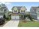 Charming two-story home with a welcoming front porch, manicured lawn, and two-car garage at 233 Pointe Park Cir, Holly Springs, NC 27540