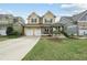 Inviting two-story home featuring a spacious front porch and a two-car garage at 233 Pointe Park Cir, Holly Springs, NC 27540