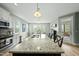 Open kitchen featuring a large island with granite counters, stainless appliances, and a view to the back deck at 233 Pointe Park Cir, Holly Springs, NC 27540